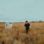 Jeni Valtinson - Music - Walking in Field with back to Camera - Headshot 8