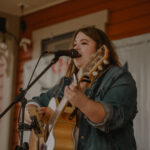 Jeni Valtinson - Music - Playing Guitar & Singing into Microphone - Headshot 6